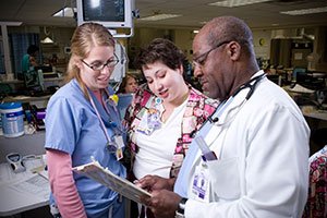 Three REX Healthcare Professionals Looking at a Clipboard