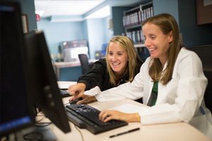 Two REX doctors looking at a computer screen