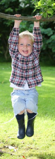 Young boy playing on treebranch