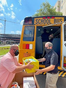 Voluteers gather supplies for school stuff the bus